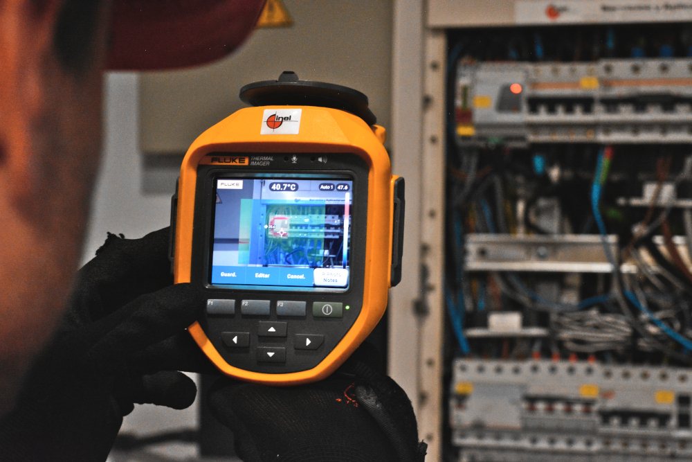 Audytor z kamerą termowizyjną przy rozdzielni elektrycznej
